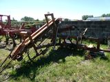 un tracteur qui est garé dans l'herbe, près d'un mur