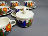 Plusieurs tasses et soucoupes sont alignées sur une table