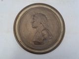 an image of a bronze medallion of a woman