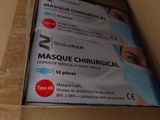 someone is opening a cardboard box with a pair of surgical masks in it