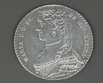 une vieille pièce d'argent sur laquelle figure le portrait d'une femme