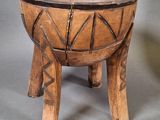 an old wooden bowl sitting on top of a wooden stand