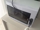 un micro-ondes blanc posé sur un meuble blanc