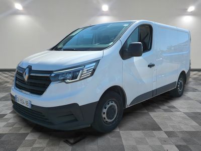 La camionnette blanche est garée dans une pièce au sol carrelé en damier.