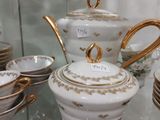 une vitrine en verre dans laquelle sont exposées une théière et des tasses
