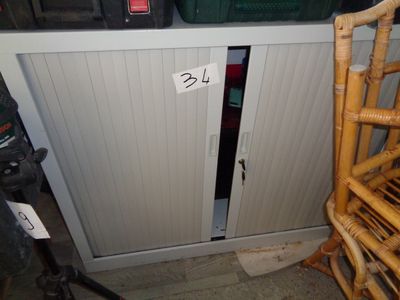 une petite armoire avec une porte et une chaise devant