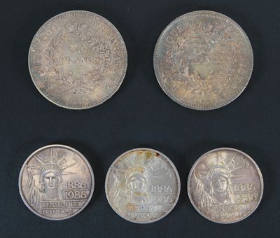 quatre types différents de pièces d'argent sur un fond noir