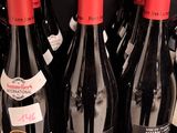 bottles of red wine are lined up on a shelf in a store