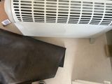une personne debout devant un radiateur posé au sol