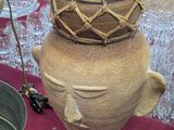a large brown vase sitting on top of a red table cloth