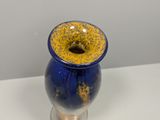a blue and yellow vase sitting on a white table
