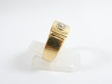 yellow gold ring with a diamond on a clear acrylic stand