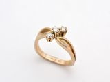 a close up of a gold ring with two diamonds on it