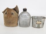 two old metal containers and a metal cup on a white surface