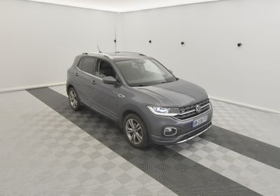 un SUV Volkswagen gris garé dans un garage au sol carrelé