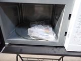 a microwave that has a bag of food inside of it