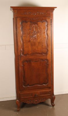 a tall wooden cabinet in the corner of a room
