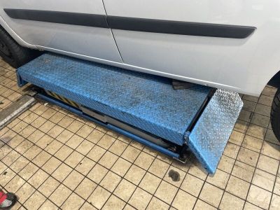 une voiture sur laquelle un mécanicien est en train de travailler