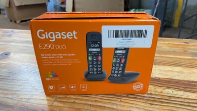 une boîte orange posée sur une table en bois, dans laquelle se trouve un téléphone