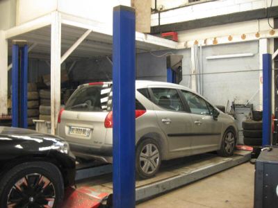 une voiture argentée sur un pont élévateur dans un garage