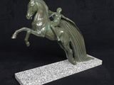 statue of a horse with a rider on its back on a marble base