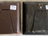two brown picture frames sitting next to each other on a table