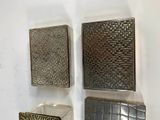 three square metal objects on a wall next to each other
