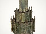 an old bronze cross with a bird on top of it