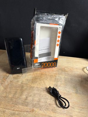 an image of a cell phone sitting on top of a table next to a charger
