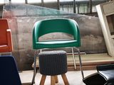 many different colored chairs and stools in a room