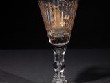 a wine glass sitting on a table with a black background