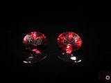 pair of red and black glass stud earrings on a black surface