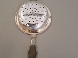 a silver spoon with a handle and a spoon in the middle of it