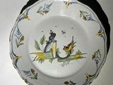 une assiette avec l'image d'une dame et d'un oiseau
