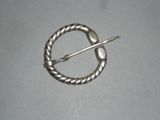 a silver brooch with a pin in the middle of it