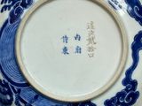 a blue and white plate with a dragon on it