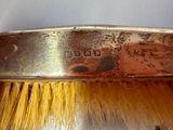 a close up of a metal brush with a yellow bristles on it