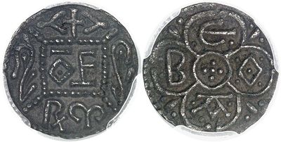 a close up of two silver coins with designs on them