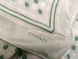 a white pillow with a green and pink flower pattern on it
