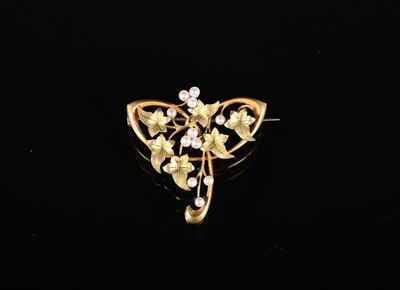 un gros plan d'une broche en or ornée de fleurs