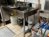 une cuisine équipée d'un évier, d'une cuisinière et d'autres éléments