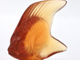 a glass fish that is sitting on a white surface