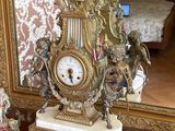 une horloge posée sur une table devant un miroir