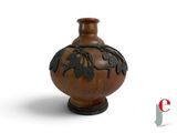 un vase marron orné d'un motif sur fond blanc