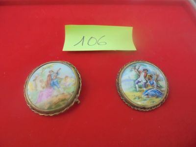 deux peintures miniatures représentant des anges, posées sur un plateau rouge orné d'un autocollant jaune