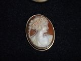 a picture of a woman in a white dress and a brown and white cameo