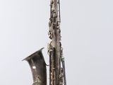 an image of a silver saxophone with a black cord on a white background