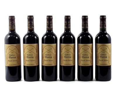 six bottles of wine are lined up on a white surface