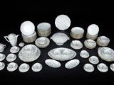 a lot of white dishes and cups on a black table