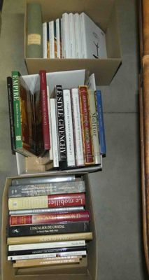 une boîte remplie de livres posée par terre à côté d'une chaise
